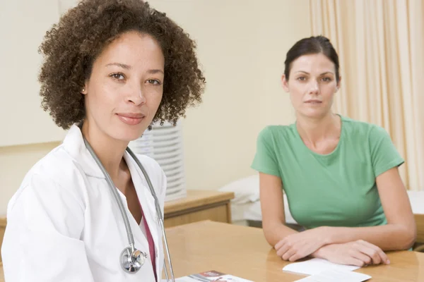 Woman in doctor's office frowning — Stock Photo, Image