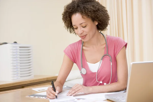Doctor with laptop writing in doctor's office — Stock Photo, Image