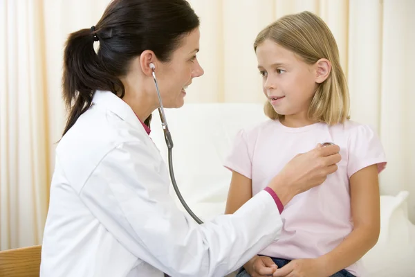 Arzt gibt Untersuchung mit Stethoskop an junges Mädchen im Untersuchungsraum — Stockfoto