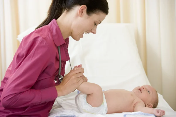 Doktor muayene odası gülümseyen içinde bebek için veren sağlık kontrolü — Stok fotoğraf