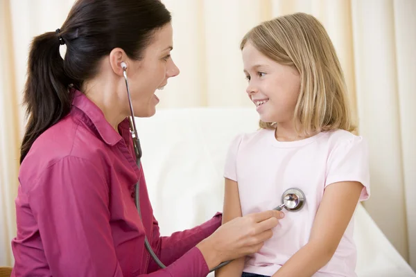 Arzt gibt Untersuchung mit Stethoskop an junges Mädchen im Untersuchungsraum — Stockfoto