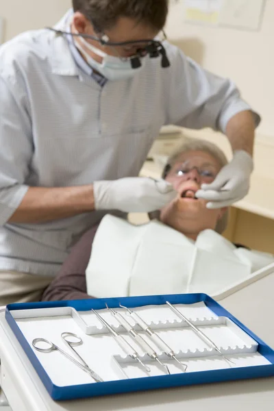 Zubař v místnosti zkoušku s ženou v křesle — Stock fotografie