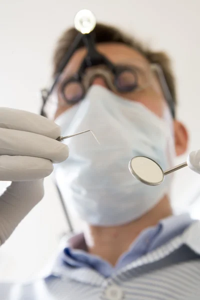 Dentist holding pick and mirror — Stock Photo, Image