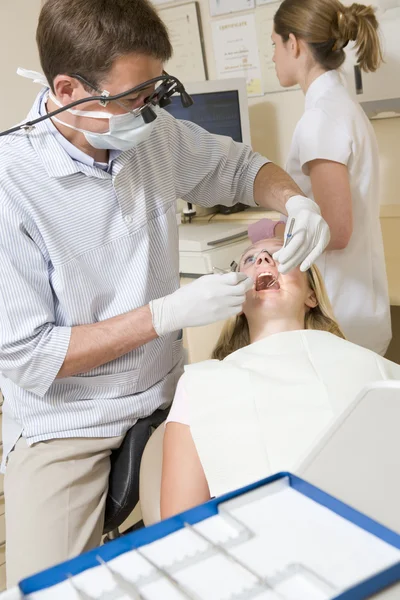 Zubař a asistent v místnosti zkoušku s ženou v křesle — Stock fotografie