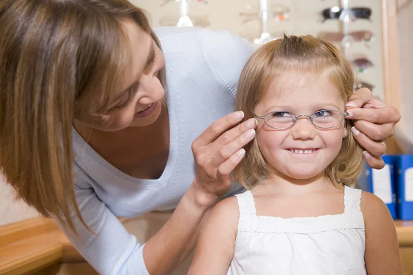 Frau Probiert Brille Auf Junges Mädchen Beim Augenarzt Lächelnd — Stockfoto