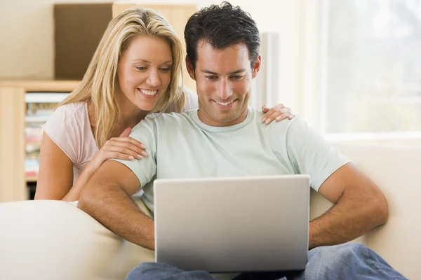 Couple dans le salon en utilisant ordinateur portable souriant — Photo