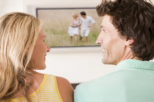 Pár, v obývacím pokoji, sledoval televizi usmívat — Stock fotografie