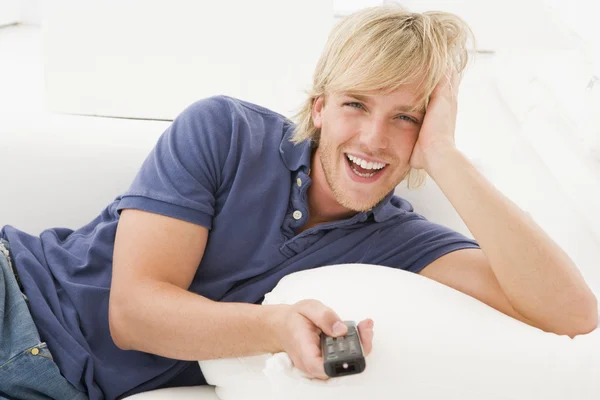 Mężczyzna Salonie Gospodarstwa Śmiejąc Się Pilot Zdalnego Sterowania — Zdjęcie stockowe