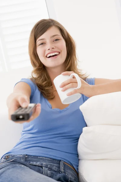 Vrouw Woonkamer Met Afstandsbediening Koffie Glimlachen — Stockfoto