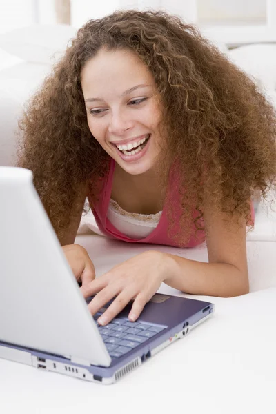Woman lying in bed with laptop smiling — Stock Photo, Image