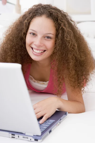 Woman lying in bed with laptop smiling — Stock Photo, Image