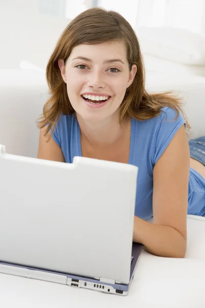 在客厅里用笔记本电脑微笑的女人 — 图库照片