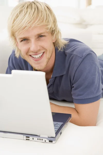 Adam Gülümseyerek Laptop Ile Oturma Odasında — Stok fotoğraf
