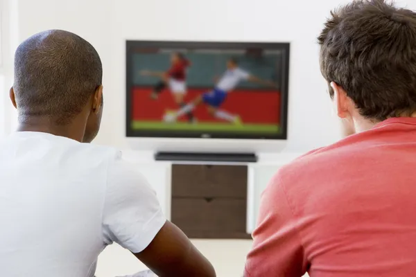 Двое мужчин в гостиной смотрят телевизор — стоковое фото