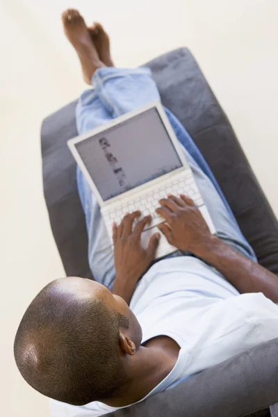 Человек, сидящий в кресле с ноутбуком — стоковое фото