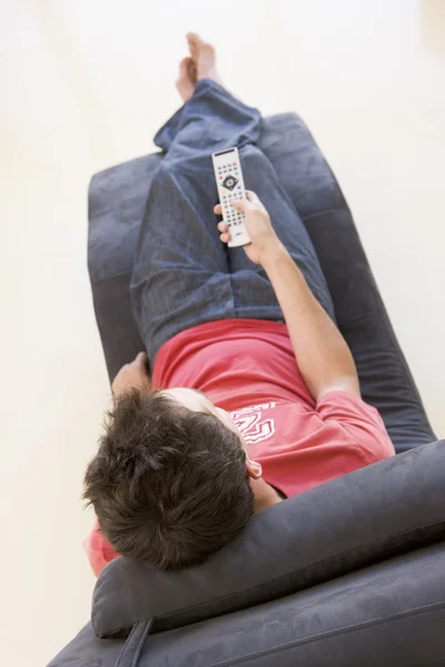 Man sitting in chair using remote control — Stock Photo, Image
