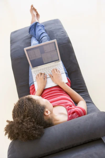 女人坐在椅子上使用的便携式计算机 — 图库照片