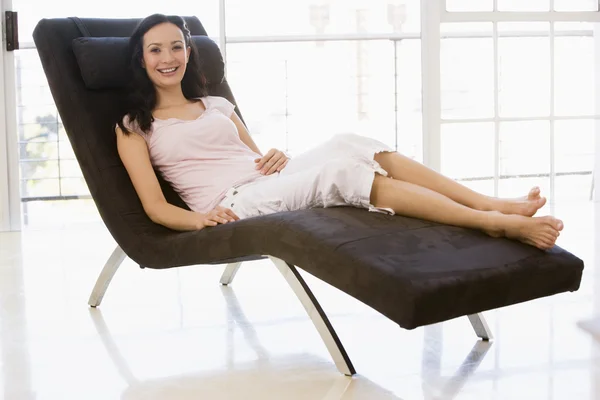 Kobieta siedząca w fotelu uśmiechający się — Zdjęcie stockowe