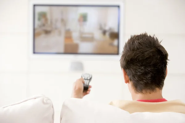 Человек в гостиной смотрит телевизор — стоковое фото