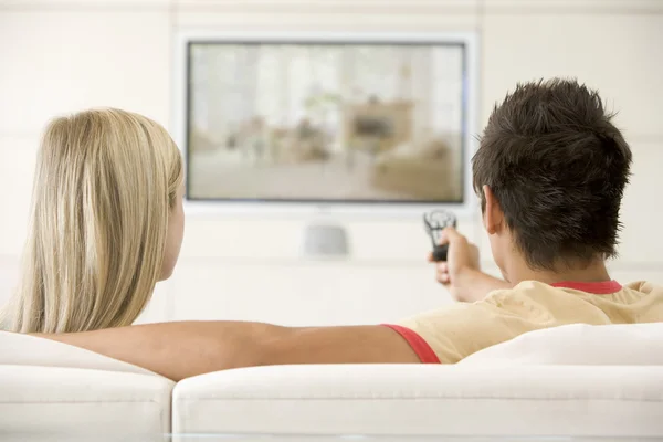 Couple in living room watching television — Stockfoto