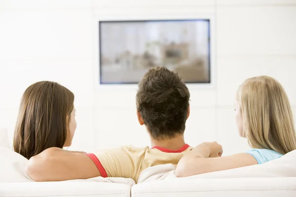 Tre amici in salotto a guardare la televisione — Foto Stock