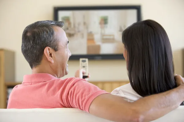 Para w salonie oglądania telewizji śmiejąc się — Zdjęcie stockowe