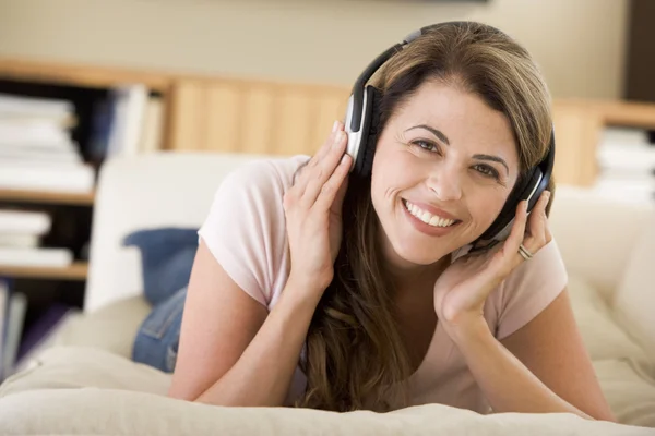 Vrouw Woonkamer Luisteren Naar Hoofdtelefoon Glimlachen — Stockfoto