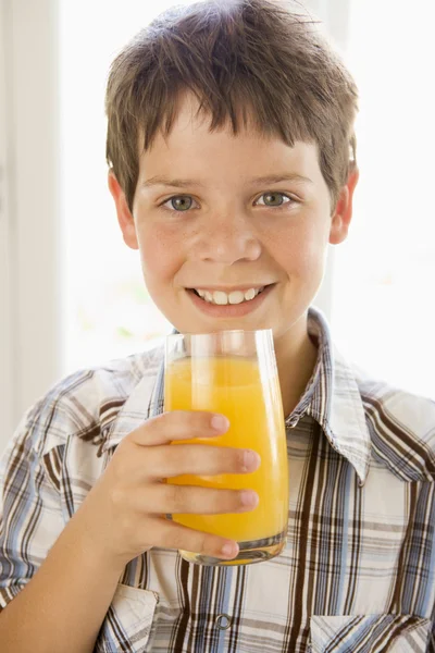 ウィンドウで屋内でオレンジ ジュースを飲む少年のポートレート — ストック写真
