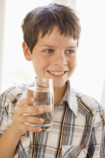 男孩喝杯水在室内靠窗的肖像 — 图库照片
