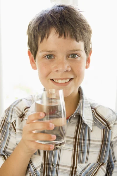 在室内喝水微笑着的小男孩 — 图库照片