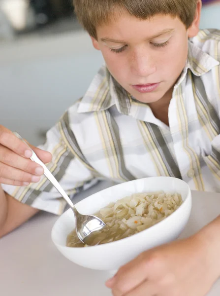 Jonge jongen in keuken eten van soep — Stockfoto