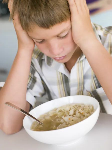 野菜スープを食べるテーブルに座っている少年 — ストック写真