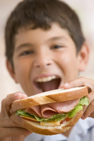 Молодий Хлопчик Їсть Бутерброд Посміхаючись — стокове фото
