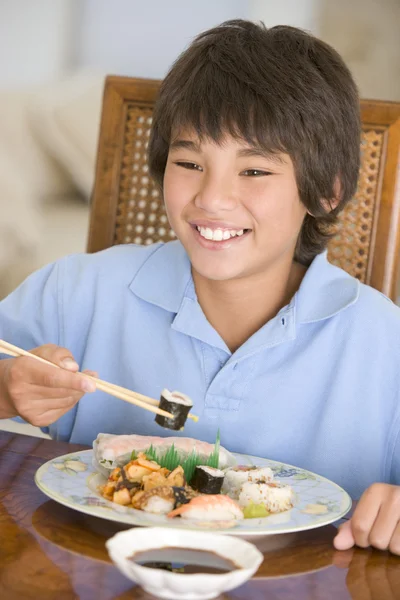 Jonge jongen in de eetzaal eten Chinees eten glimlachen — Stok fotoğraf