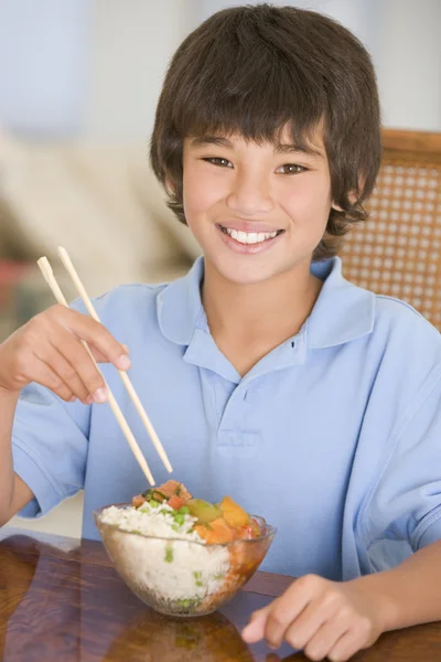 Jonge jongen in de eetzaal eten Chinees eten glimlachen — Stockfoto