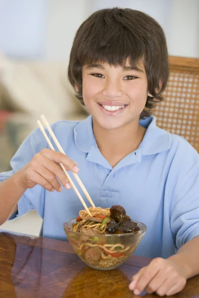 Jonge jongen in de eetzaal eten Chinees eten glimlachen — Stockfoto