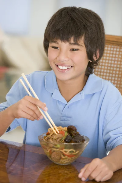 Giovane ragazzo in sala da pranzo mangiare cibo cinese sorridente — Foto Stock