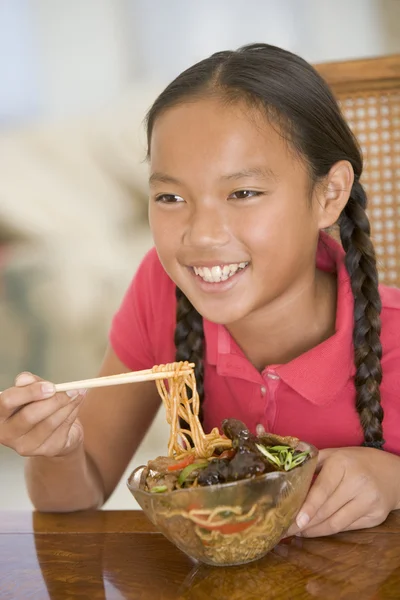 Νεαρό κορίτσι στην τραπεζαρία τρώει κινέζικο φαγητό χαμογελώντας — Φωτογραφία Αρχείου