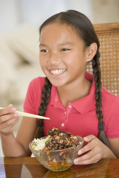 Ung flicka i matsalen äter kinesisk mat leende — Stockfoto
