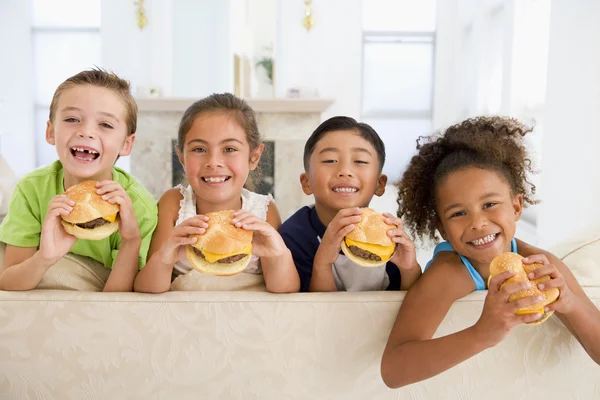 Vier Jonge Kinderen Eten Cheeseburgers Woonkamer Glimlachen — Stockfoto