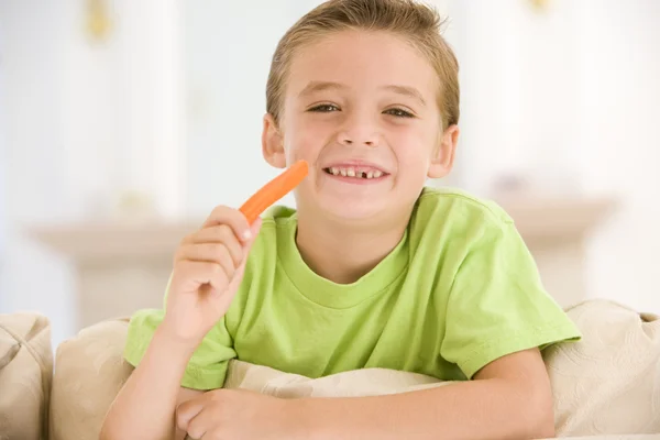 Молодий Хлопчик Їсть Морквяну Паличку Вітальні Посміхається — стокове фото