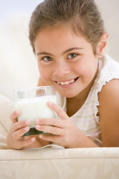喝牛奶在客厅里微笑的小女孩 — 图库照片