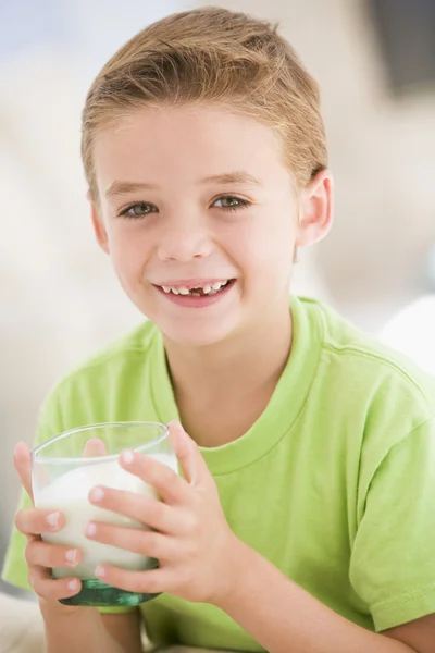 在室内喝牛奶微笑的小男孩 — 图库照片