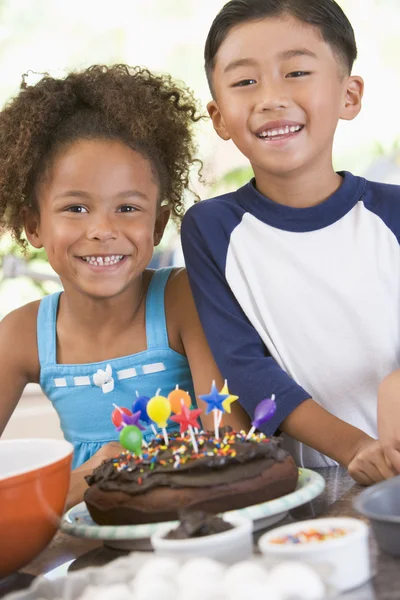 Doğum günü pastası gülen ile mutfakta iki çocuk — Stok fotoğraf