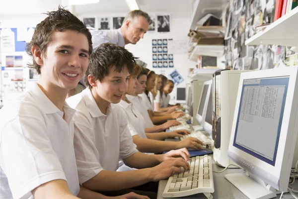 Fila di scolari che studiano davanti a un computer Foto Stock