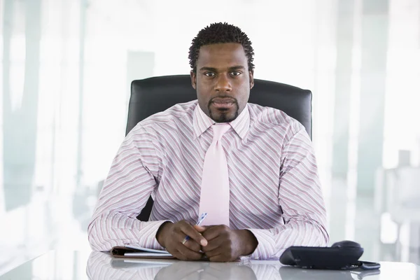 Businessman sitting in office with personal organizer — Stock Photo, Image