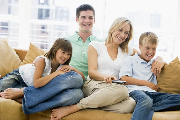 Família Sentada Sala Estar Com Controle Remoto Sorrindo — Fotografia de Stock