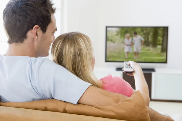 在客厅里看电视的夫妇 免版税图库图片