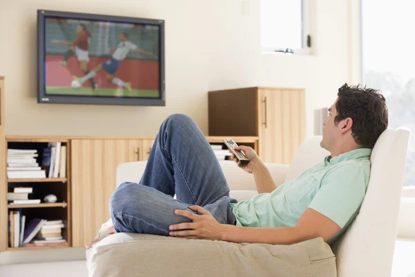 Man in living room watching television Stock Image