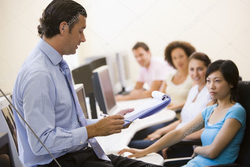 Man with clipboard giving lecture in computer class ⬇ Stock Photo